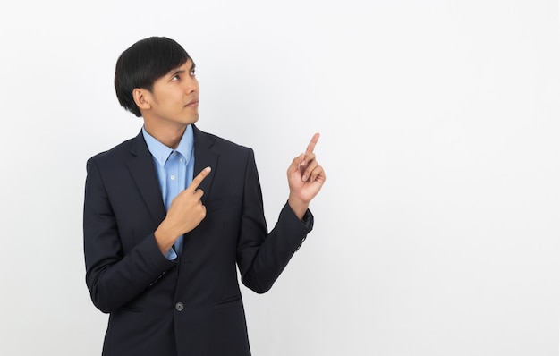 Young asian business man with blue shirt pointing to the side with a hand to present a product or an idea isolated on white