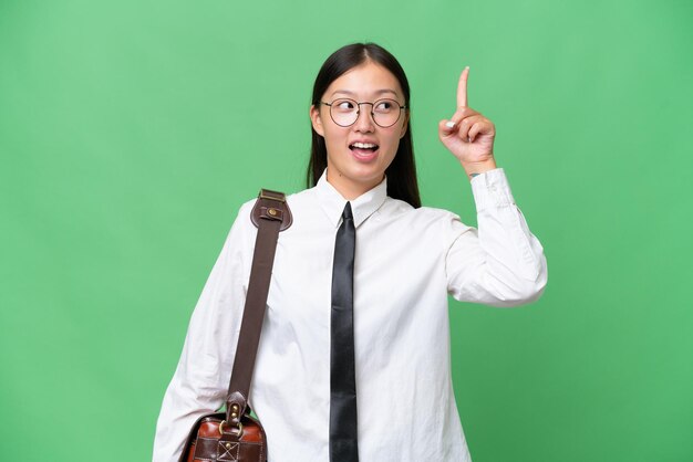 Young Asian business woman over isolated background intending to realizes the solution while lifting a finger up