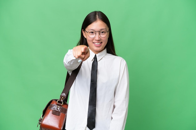 Young Asian business woman over isolated background points finger at you with a confident expression