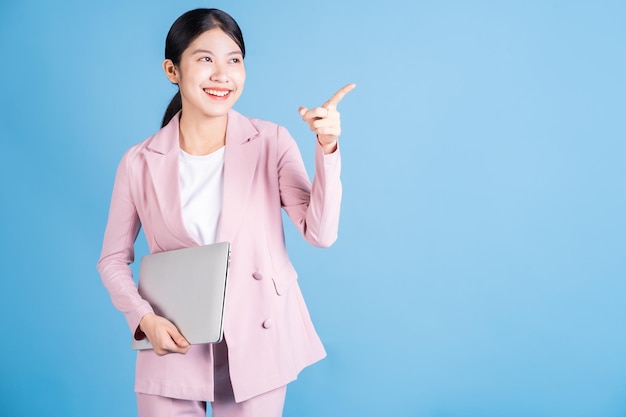 Young Asian business woman using laptop on background