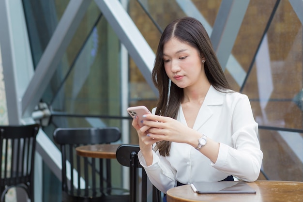 Young Asian business woman who has long hair is playing and looking at in her hands to check