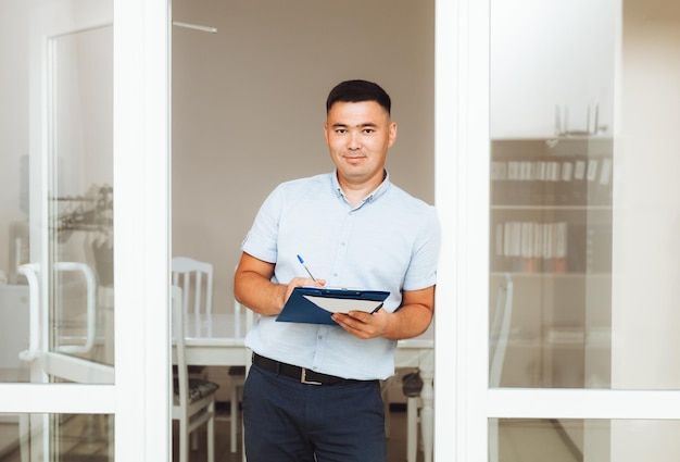 A young Asian businessman with his arms crossed on his chest in the office portrait of a business man