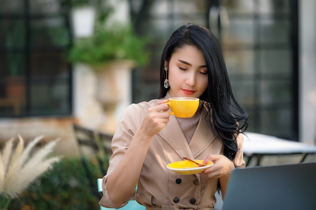 Young asian businesswoman and freelance sitting on wooden table