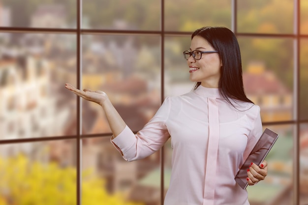 Young asian businesswoman holding tablet pc and showing copy space