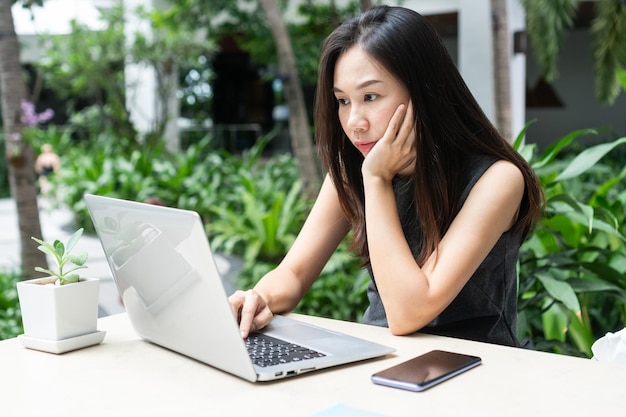 Young Asian businesswoman is working on laptop computer Work from home business and technology concept