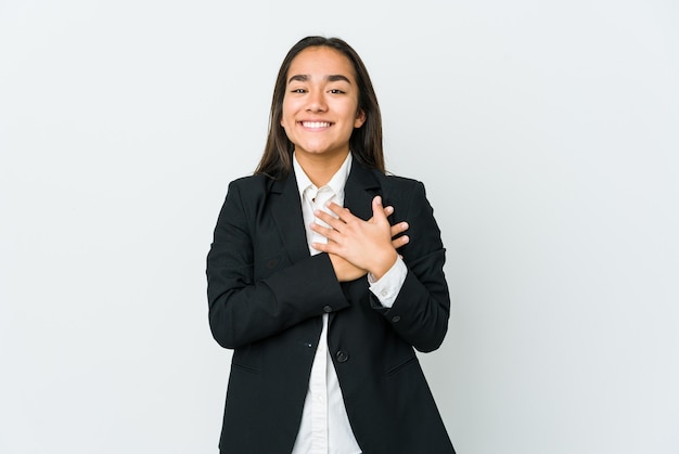 Young asian businesswoman isolated on white wall has friendly expression, pressing palm to chest. Love concept.