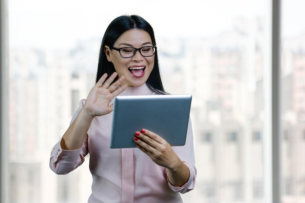 Young asian businesswoman to someone via tablet pc