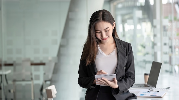 a young asian businesswoman taking notes at the office.