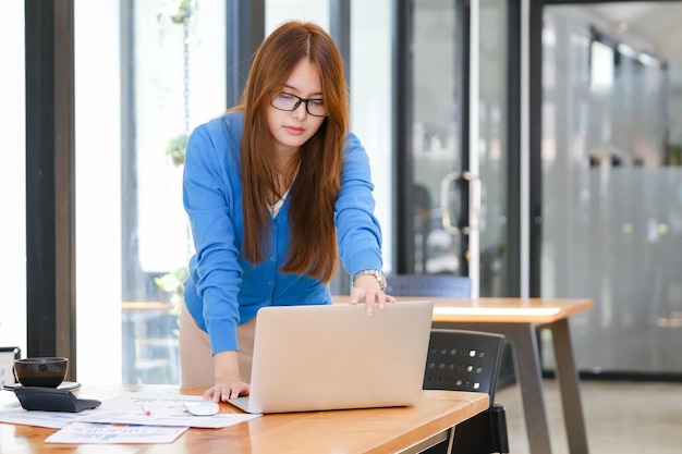 Young asian businesswoman working at office using laptop