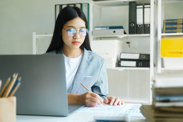 Young asian businesswoman working at office using laptop