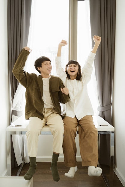 Young asian couple dancing together at home