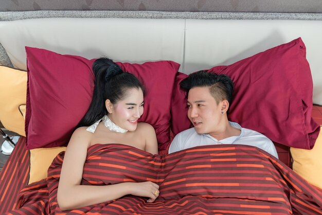 Young asian couple looking eyes together on the bed