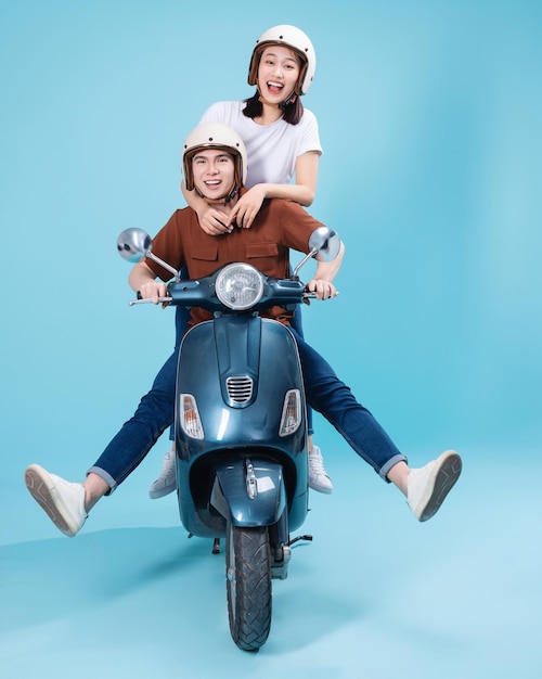 Young Asian couple ride scooter on background