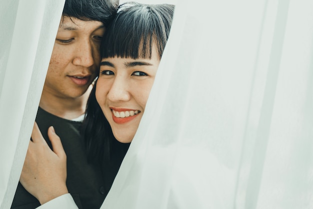 young asian couple smiling together on white