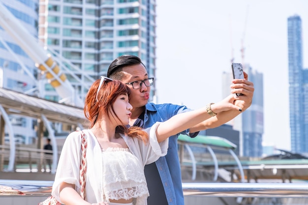 Young asian couple travel summer vacation or honeymoon trip taking selfie