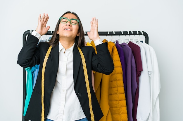 Young asian designer woman isolated on white background screaming to the sky, looking up, frustrated.