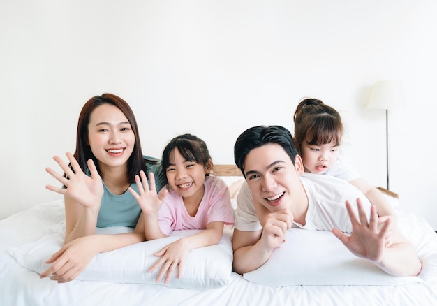 Young Asian family on bed