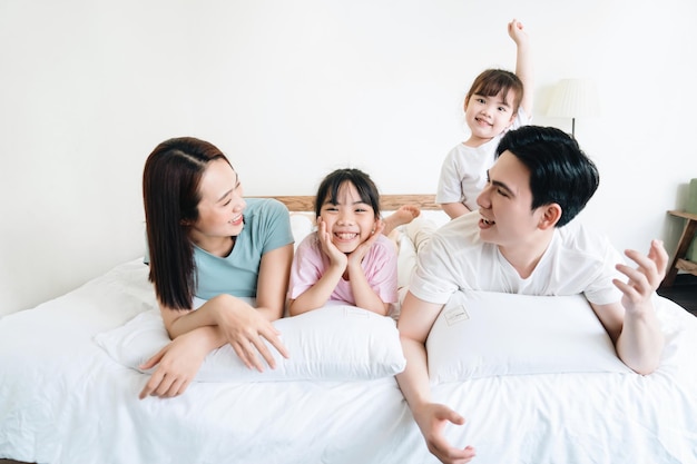 Young Asian family on bed