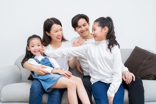 Young Asian family entertained at home in free time