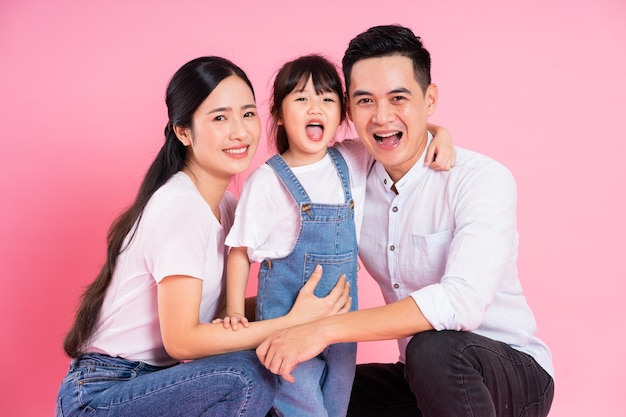 Young asian family image isolated on pink background