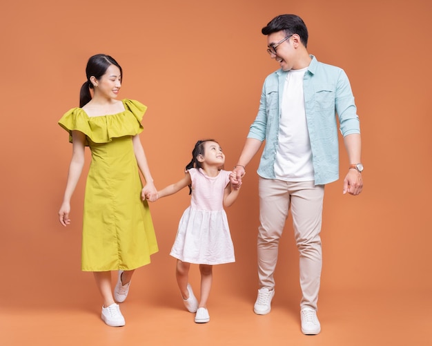 Young Asian family posing on background