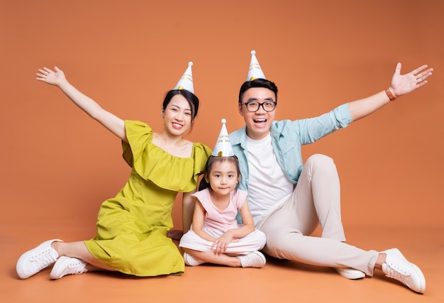 Young Asian family posing on background