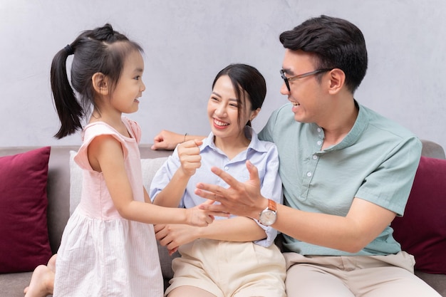 Young Asian family sitting on sofa