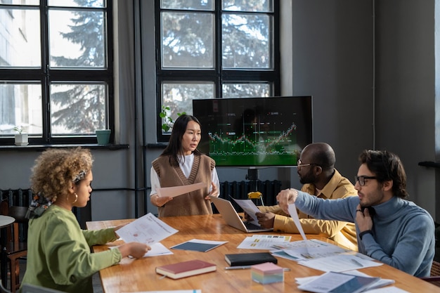 Young asian female economist with document making presentation