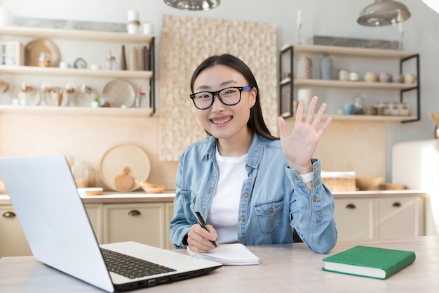 Young asian female student studying remotely at home portrait of woman with laptop on online