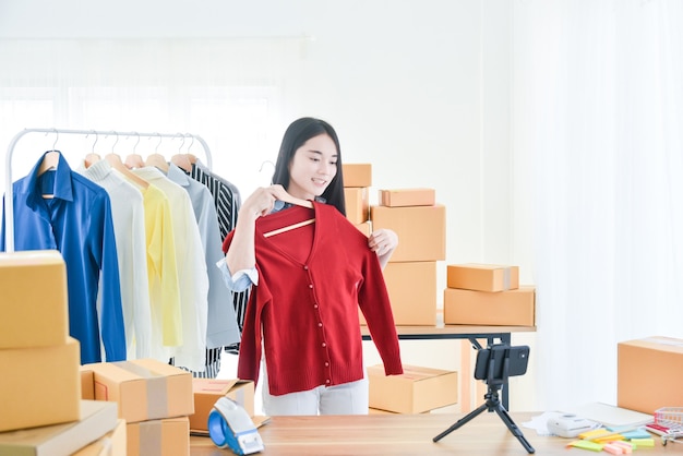 Young Asian girl selling clothes online by live streaming