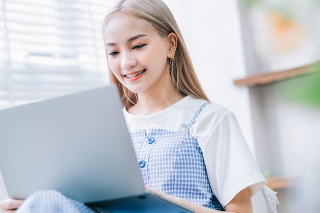 Young Asian girl using laptop at home