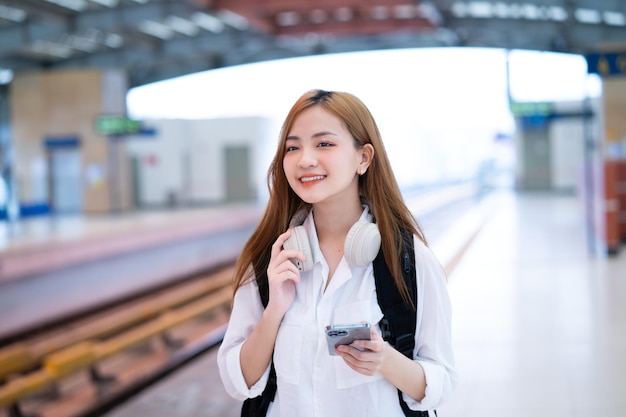 Young Asian girl waiting for the train at the station