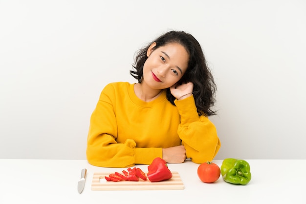 Young asian girl with vegetables in a table