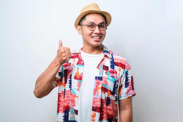 Young asian man approving doing positive gesture with hand thumbs up smiling and happy for success Winner gesture