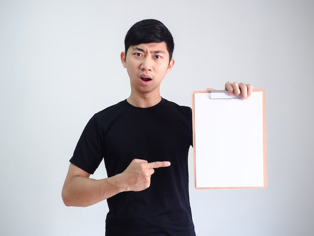 Young Asian man black shirt point finger at wood clipboard blank document in hand serious face