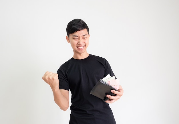 Young Asian man black shirt show fist up and happy face with money in wallet in hand