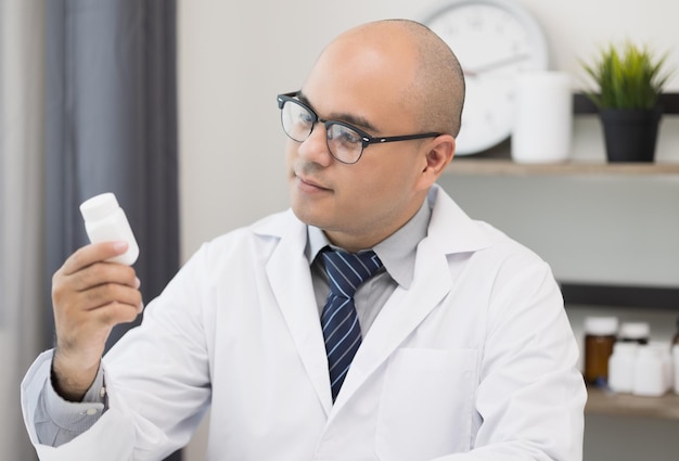 Young asian man doctor works from home working online looking and camera talking with patient Explain about taking medications to treat illnesses