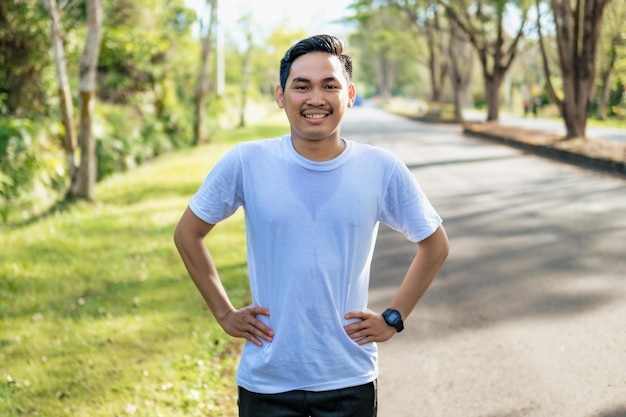 Young Asian man doing stretching exercise preparing for running in the nature Healthy lifestyle