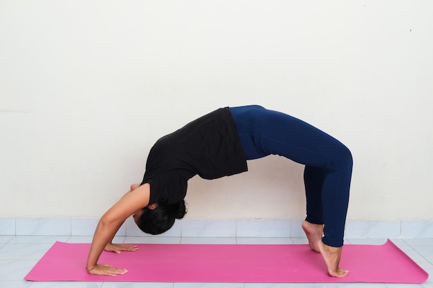 Young Asian man doing yoga pose above sport mattress