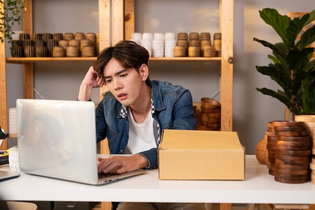 A young Asian man entrepreneur feeling disappointed with his business growth in his shop