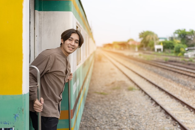 young asian man hand to say hello or goodbye to friend on train,  