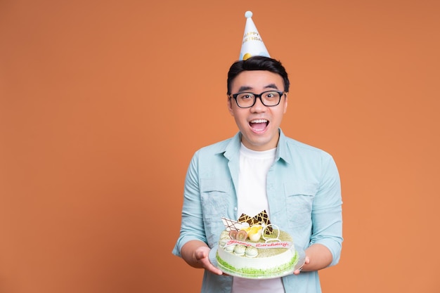 Young Asian man holding birthday cake