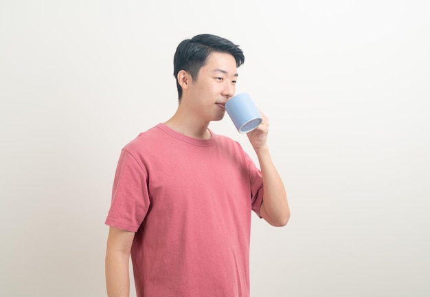 Young Asian man holding coffee cup with smiling face on white background