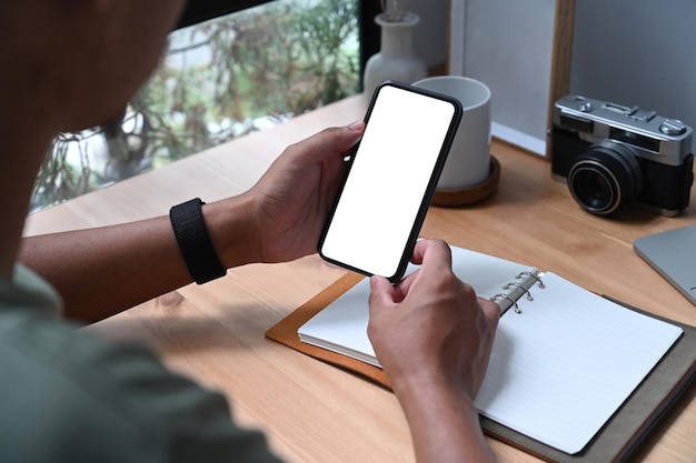 Young asian man holding smart phone with white screen.