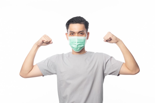 Young Asian Man in hygienic mask showing strength to prevent infection, 2019-nCoV or coronavirus. Airborne respiratory illness such as pm 2.5 fighting and flu.on white background