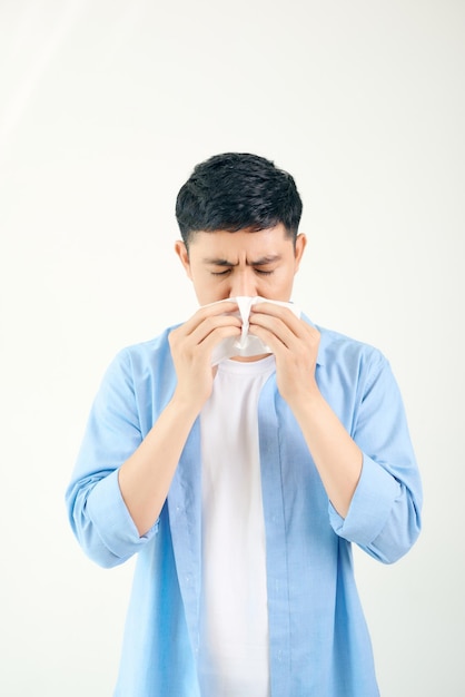 Young asian man sneezing after get allergy or flu virus and using tissue paper for swipe on nose at medical clinic after got coronavirus covid19 disease for unhealthy lifestyle concept