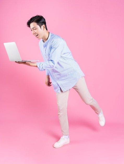 Young Asian man using laptop in background