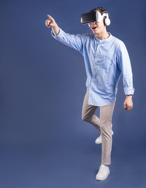 Young Asian man using VR glassses on backgroud