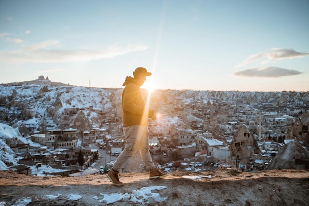 Young asian man walking alone in beautiful snowy city of cappadocia landscape