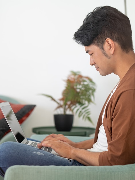 Young asian man wearing casual clothes and using laptop